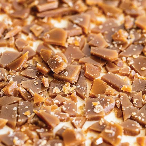 Homemade toffee cooling on a parchment-lined baking sheet